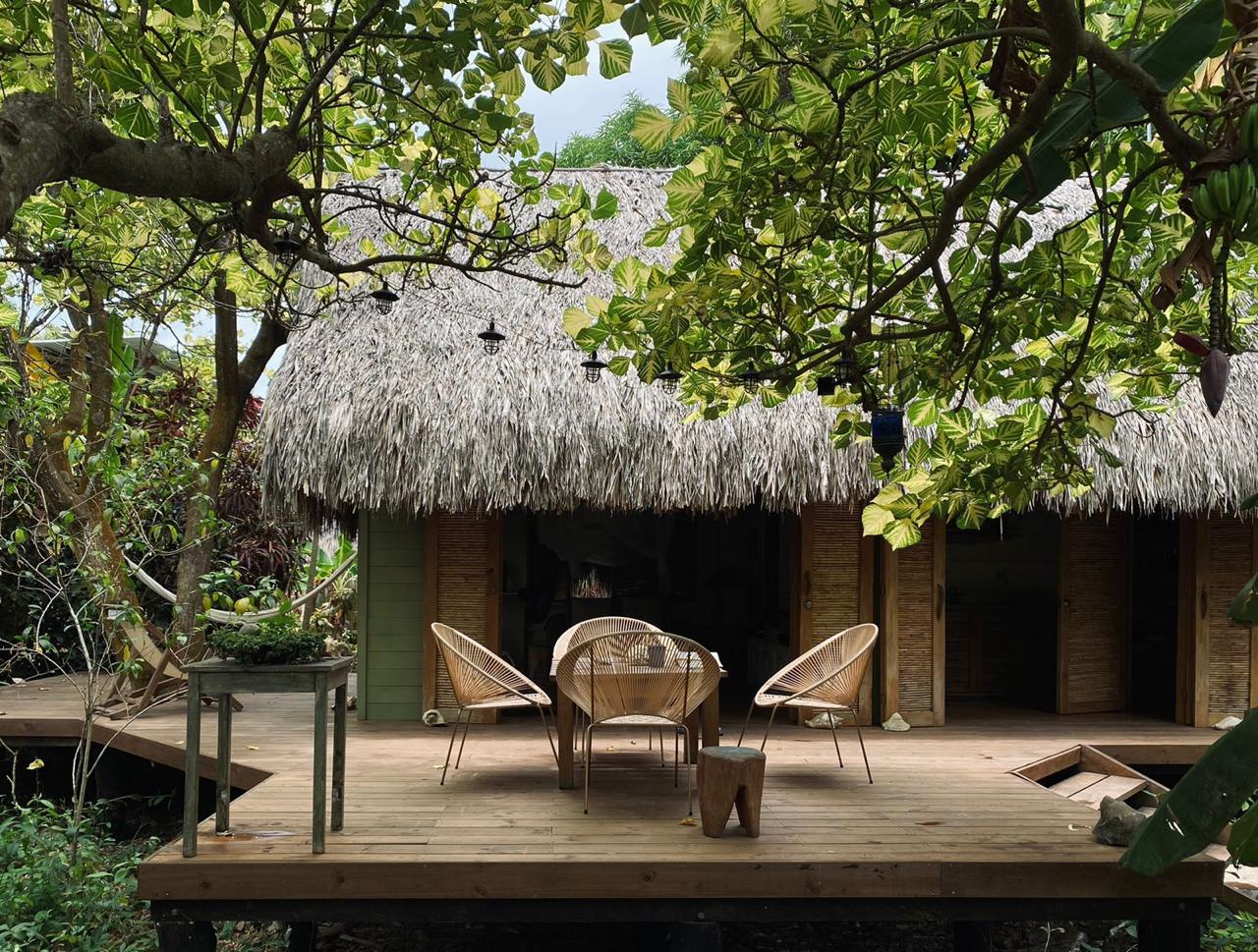 Deck y fachada de Agua de Luna Creciente entre jardín tropical