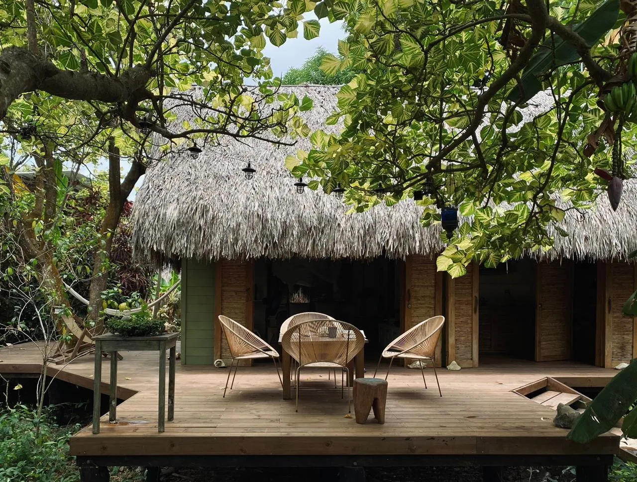 Deck y fachada de Agua de Luna Creciente entre jardín tropical