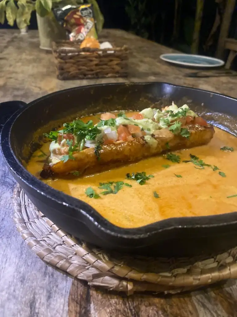Plátano frito en salsa servido en sartén de hierro